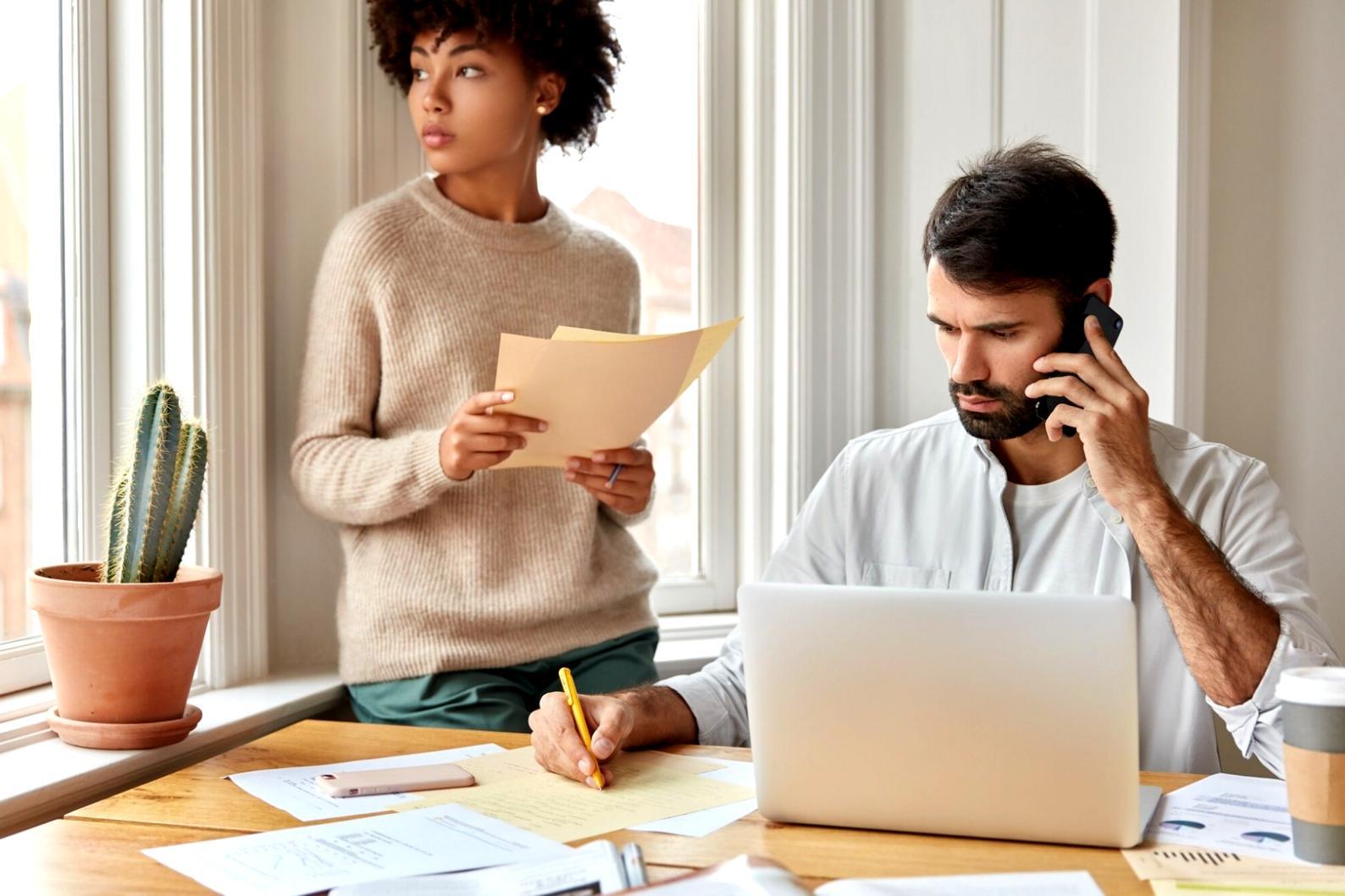 Professionelle Beratungssituation mit Finanzunterlagen und Laptop auf einem modernen Schreibtisch